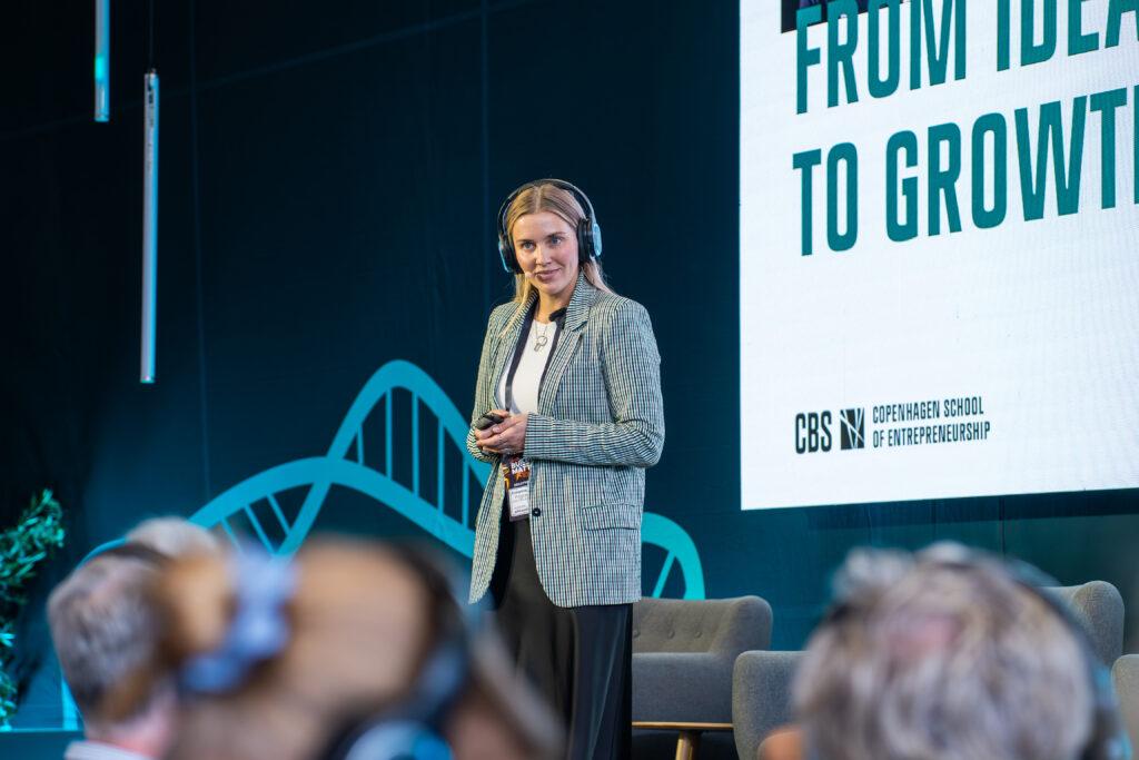 A woman on stage at TechBBQ giving a presentation