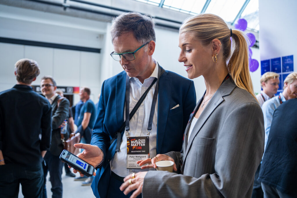 Two people in conversation holding a phone, an app is visible: the president of CBS Peter Møllgaard and Co-founder of the wadrobe app Keypitt, Karla Pitt Winther