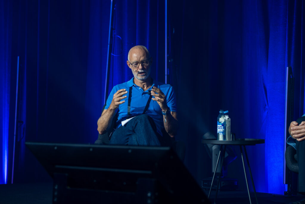 Dean of Research Søren Hvidkjær sitting on stage during the panel discussion